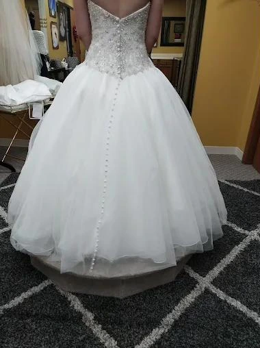 The back of a ball gown with a beaded bodice and a row of small buttons